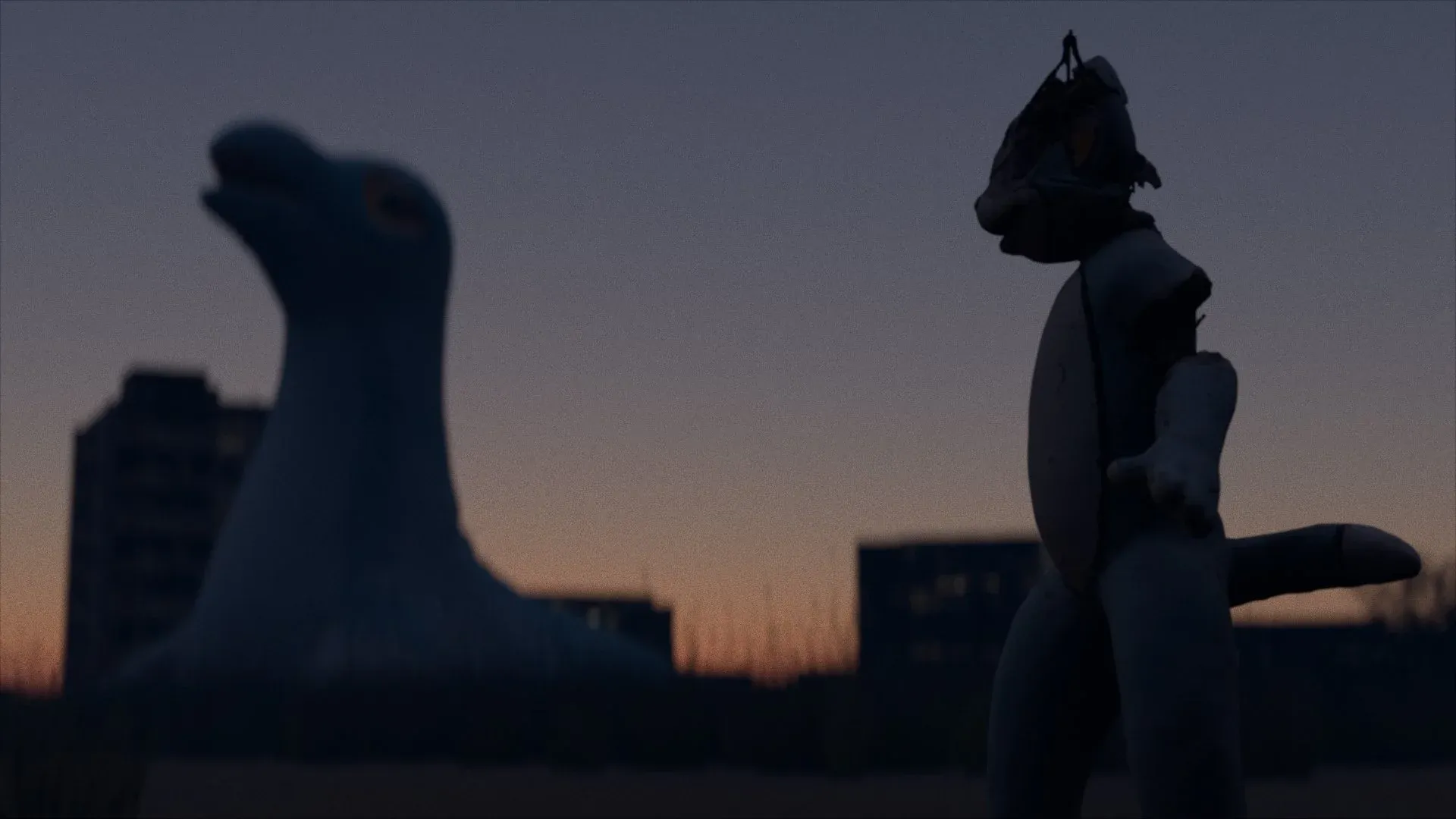 Two weathered playground animal sculptures standing in a reconstructed landscape at dusk.